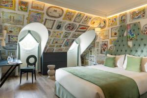 a bedroom with a bed and a wall of pictures at Hôtel Le Magnifique Ex Hôtel Le M in Paris