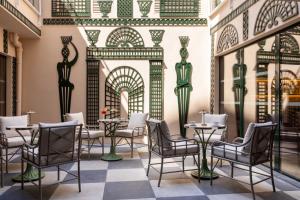 a dining room with tables and chairs and a wall with an arabic design at Hôtel Le Magnifique Ex Hôtel Le M in Paris