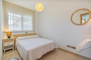 a small bedroom with a bed and a mirror at Planta baja Marita in Deltebre +12 photos