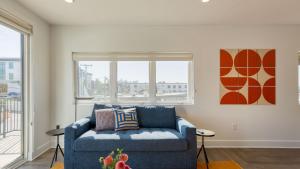 a living room with a blue couch and a window at The Carter by AvantStay in Nashville