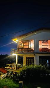 a large white house with a balcony at night at travellers nest inn in Nuwara Eliya