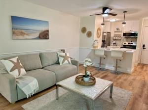 a living room with a couch and a table at New Cape Cod Condo Near Beaches in Brewster +5 photos