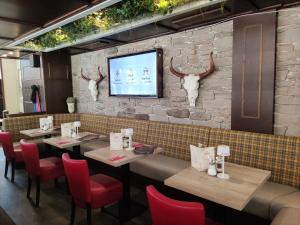 a restaurant with tables and chairs and a tv on a brick wall at Hotel Am Hopfenmarkt in Rostock