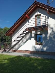a white building with a balcony and a window at Apartament Miłków Karkonosze in Miłków