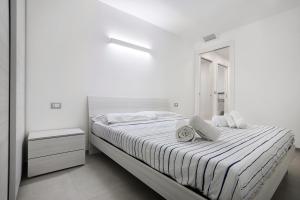 a white bedroom with a bed and a mirror at Sea House Superior in Pietra Ligure