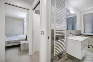 a white bathroom with a sink and a bed at Sea House Superior in Pietra Ligure +16 photos