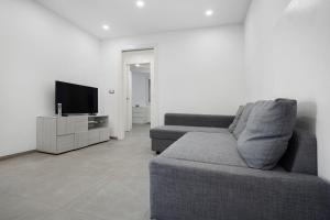 a living room with a couch and a television at Sea House Superior in Pietra Ligure