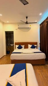a bedroom with two beds and a ceiling at Hotel Vakula Matha Grand in Tirupati