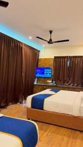a bedroom with two beds and a ceiling fan at Hotel Vakula Matha Grand in Tirupati +1 photo
