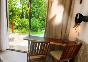 a desk with two chairs in front of a window at Casa Lamat in Bacalar