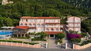 a large house with a pool in front of a mountain at Lido Corfu Sun Hotel 4 Stars All-inclusive in Benitses