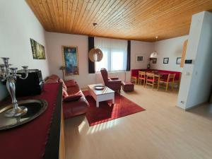 a living room with a couch and a table at Obergeschoss Bungalow 47 in der Ferienanlage RHÖN RESIDENCE in Dipperz