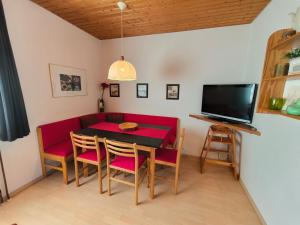 a dining room with a red table and chairs at Obergeschoss Bungalow 47 in der Ferienanlage RHÖN RESIDENCE in Dipperz