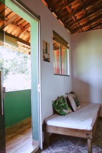 a room with a bench in a room with a window at LahSelva Pousada e Hostel in Itacaré
