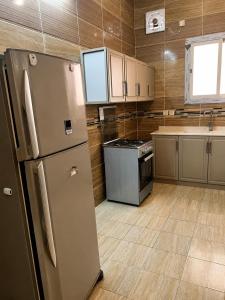 a kitchen with a refrigerator and a stove at البساتين هومز - Al Basateen Homes in Al Baha