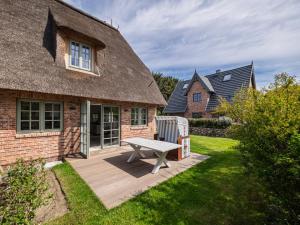 a wooden deck with a bench in front of a house at Landhaus Sylter Hahn in Westerland