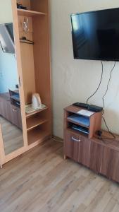 a living room with a television on a wooden cabinet at Guesthouse Marton in Jezerce