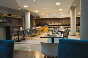 a restaurant with tables and chairs and a bar at City Falls Iguazú in Puerto Iguazú