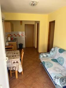 a room with a bed and a table and a kitchen at Villa Oliva Vir in Vir