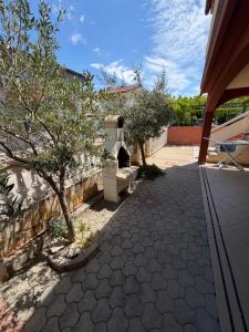 a garden with a stone walkway with trees and a building at Villa Oliva Vir in Vir +4 photos