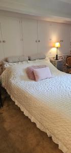 a large white bed with a pillow on it at Chambre d'hôtes Le Lupin Bleu in Saint-Coulomb