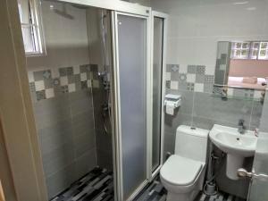 a bathroom with a shower and a toilet and a sink at Cozy Modern Quiet Garden in Tanah Rata +33 photos