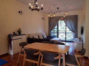a living room with a table and a couch at Cozy Modern Quiet Garden in Tanah Rata
