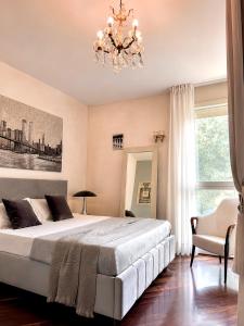 a bedroom with a large bed and a chandelier at Villa Nuvola Suites in Fiorano Modenese +76 photos