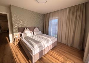 a bedroom with a bed and a window at SINGULAR - Mountainview Apartments in Bad Goisern