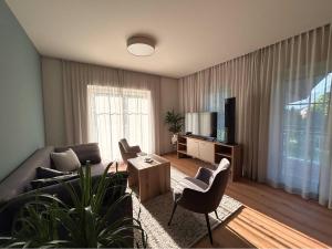 a living room with a couch and chairs and a tv at SINGULAR - Mountainview Apartments in Bad Goisern +10 photos