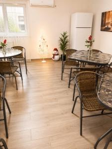 a room with tables and chairs and a refrigerator at Grey in Călimăneşti