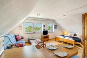 a living room with a bed and a table at Haus Achtern Diek - Ferienwohnungen in Wangerland
