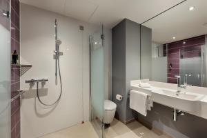 a bathroom with a shower and a toilet and a sink at Premier Inn Hannover City Centre in Hannover +55 photos