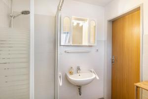a bathroom with a sink and a shower at Haus Achtern Diek - Ferienwohnungen in Wangerland +64 photos