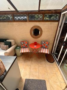 a small patio with a red table and chairs at Railmans Rest in Faversham +20 photos