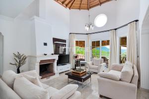 a living room with white furniture and a fireplace at TEKCE Yeşilüzümlü Villa No 17 in Uzumlu