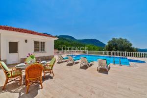 a patio with a table and chairs next to a pool at TEKCE Yeşilüzümlü Villa No 17 in Uzumlu