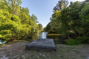 a small river with a wooden dock on the shore at 3021 - Southern Snores in Kitty Hawk Beach