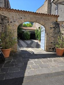 an archway in a stone wall with a door at La Tour Noble in Saint-Saturnin