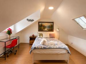 a attic bedroom with a bed and a desk at ChinaTown Boutique Rooms in Toronto