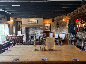 a wooden table in a restaurant with a fireplace at The Hunters Rest Inn in Clutton