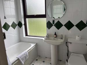 a bathroom with a tub and a sink and a toilet at Diamond View House in Letterfrack +19 photos