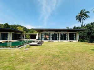 a house with a pool and a grass yard at Laman Villa Port Dickson in Port Dickson