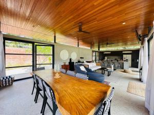 a dining room with a large wooden table and a living room at Laman Villa Port Dickson in Port Dickson