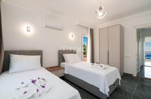 two beds in a bedroom with a view of the ocean at TEKCE Villa Motto N21 in Kaş +56 photos