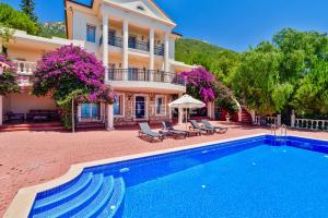 a house with a swimming pool in front of a house at TEKCE Villa Motto N21 in Kaş
