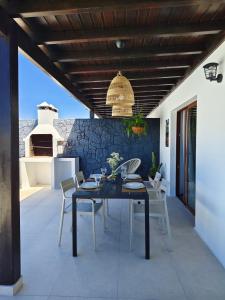 a patio with a black table and white chairs at Villas Rodríguez in Playa Blanca