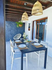 a dining table with white chairs and a blue table and chairsktop at Villas Rodríguez in Playa Blanca
