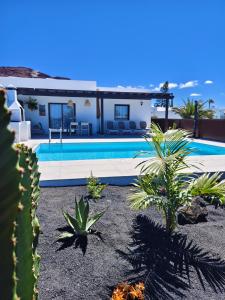 a house with a swimming pool and some plants at Villas Rodríguez in Playa Blanca