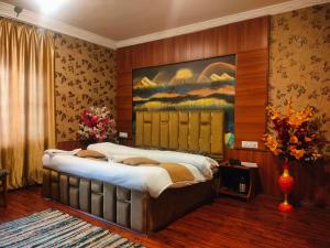 a bedroom with a large bed with a painting on the wall at Basera Residency Shalimar in Bāgh Chandpura